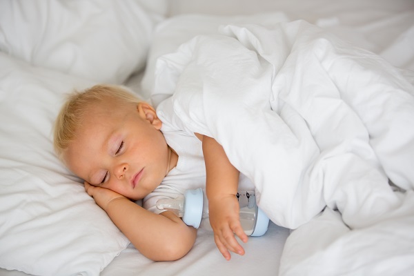 Baby sleeping holding their bottle