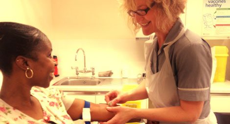 Practice nurse with patient taking blood