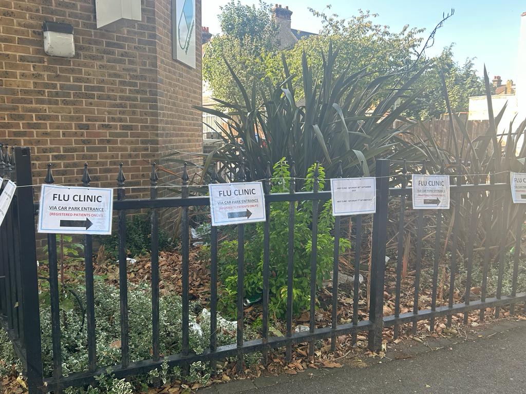 flu clinic signs on the surgery fencing